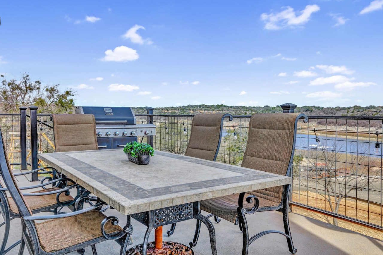 Alfresco dining with lake views at this Spicewood vacation rental