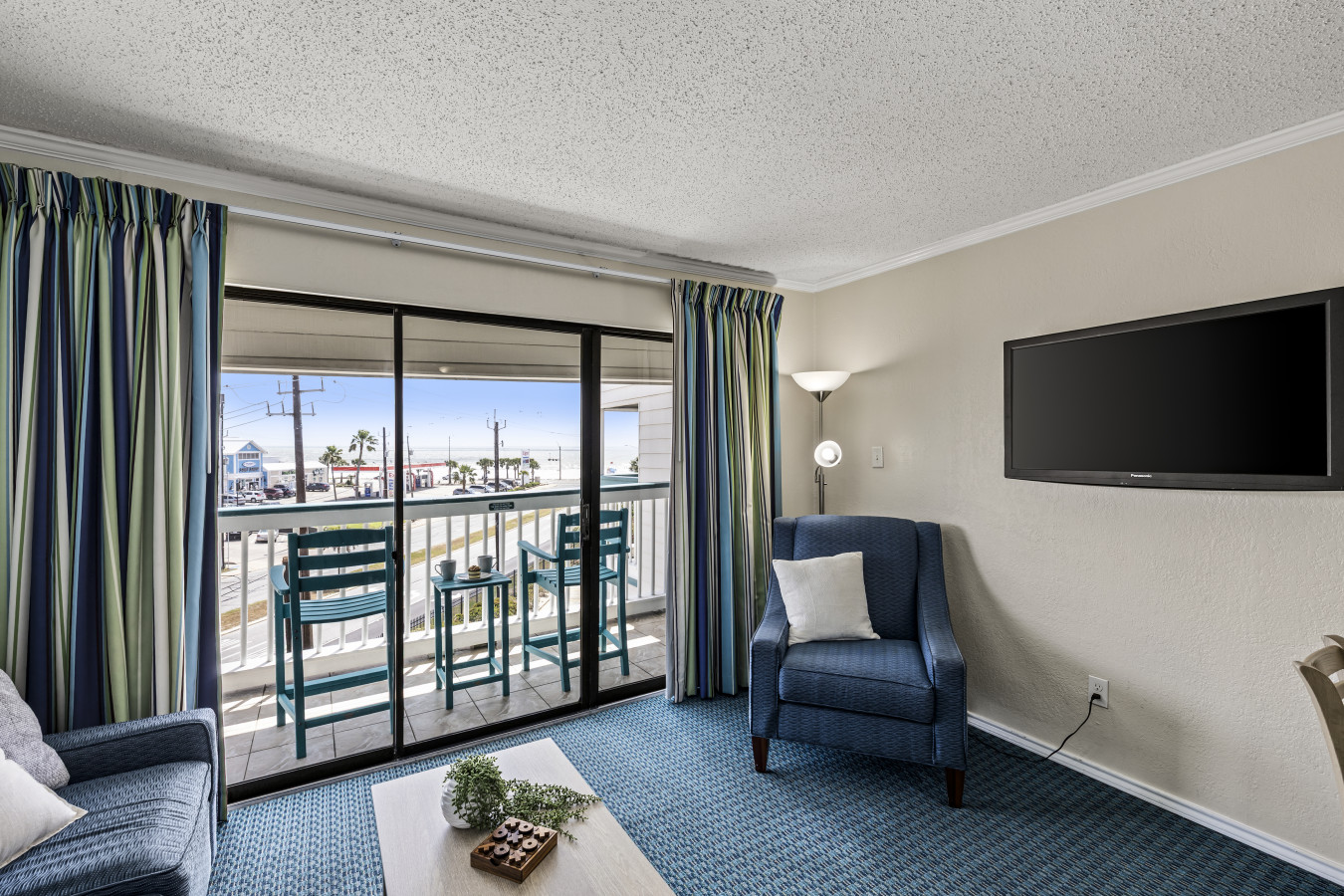 Bright coastal living area with balcony access at Condo 335—relax with natural light and comfortable seating