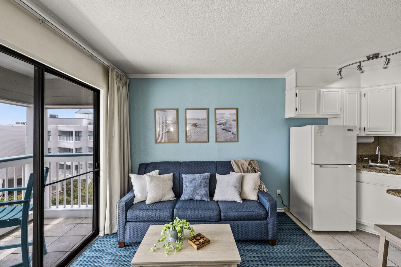 Bright, coastal living space with open kitchen and balcony access—designed for easy, comfortable beachside living.