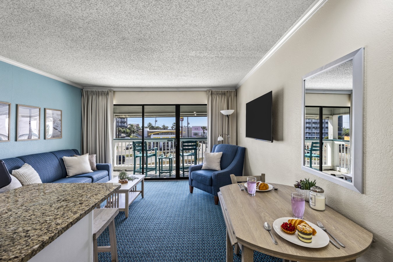 Inviting living room with comfortable seating and balcony access—perfect for relaxing after a day exploring Galveston.