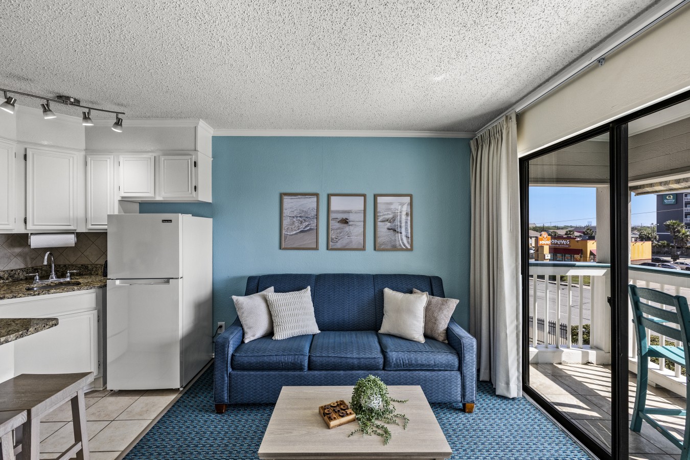 Bright, coastal living space with open kitchen and balcony access—designed for easy, comfortable beachside living.