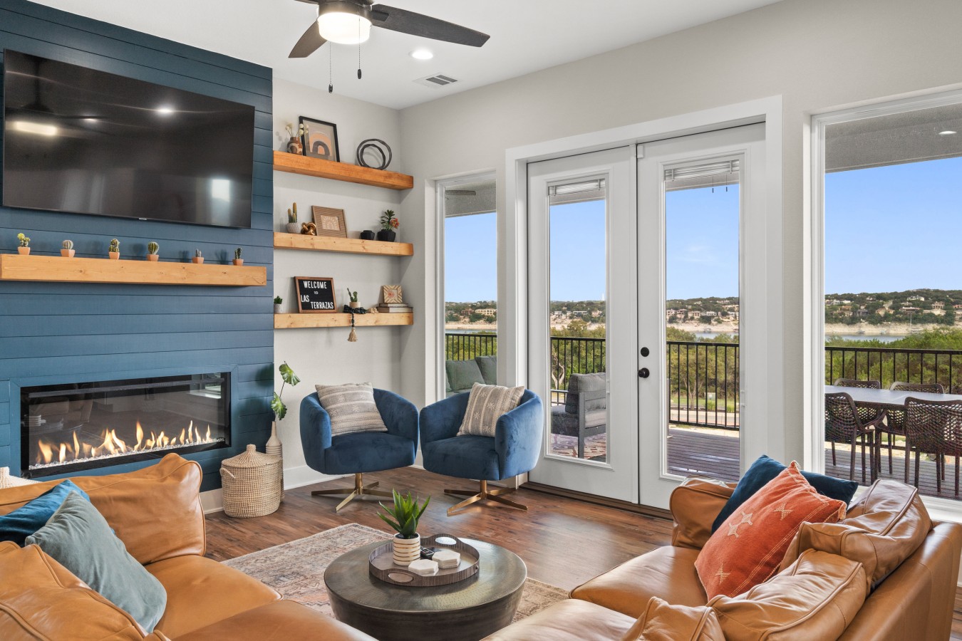 Lake Travis views fill this inviting living room, where a modern electric fireplace and comfortable seating create an elevated gathering space.