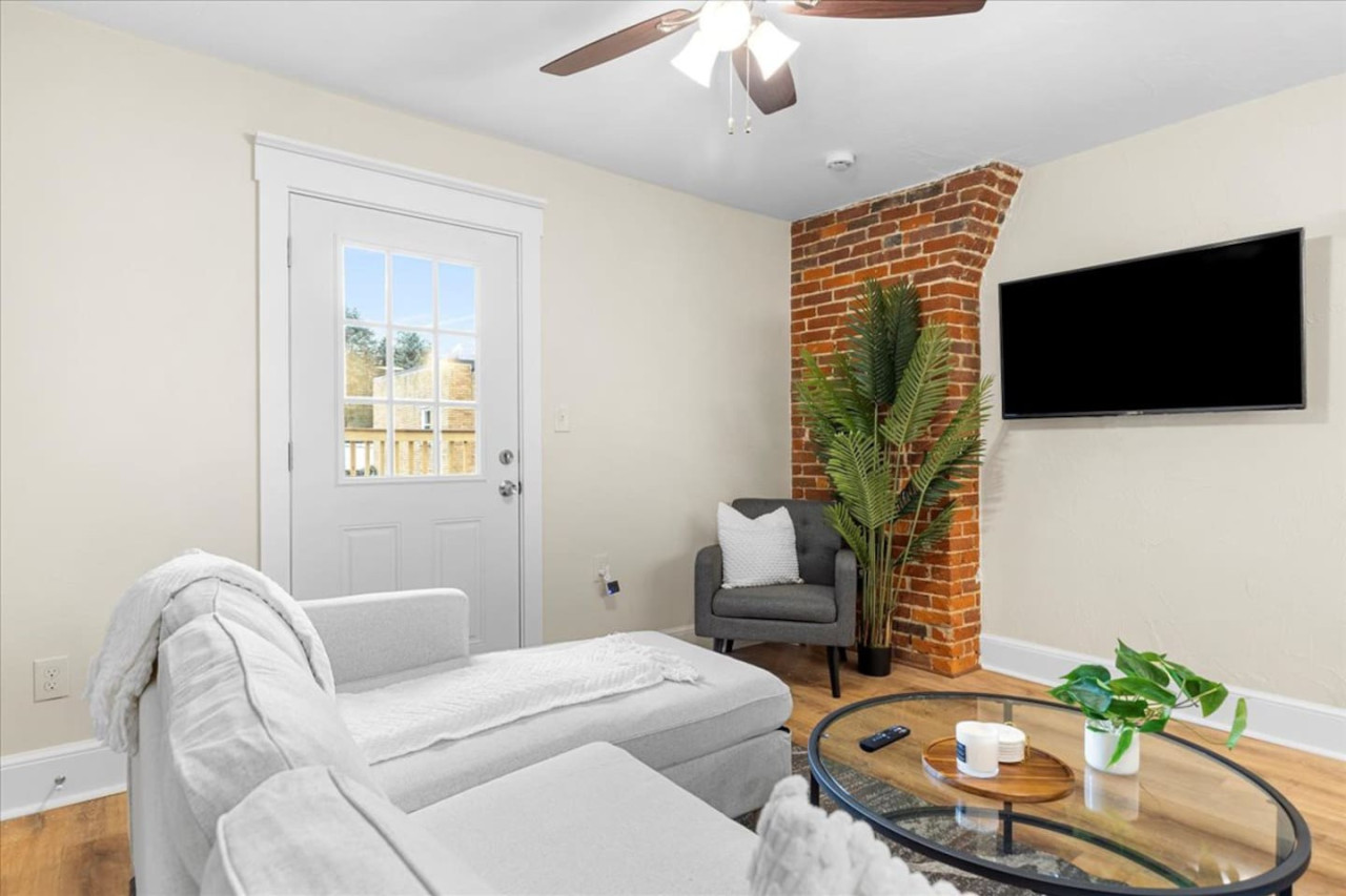The living room’s cozy vibe makes it the perfect spot to relax, with ample seating and a warm ambiance.