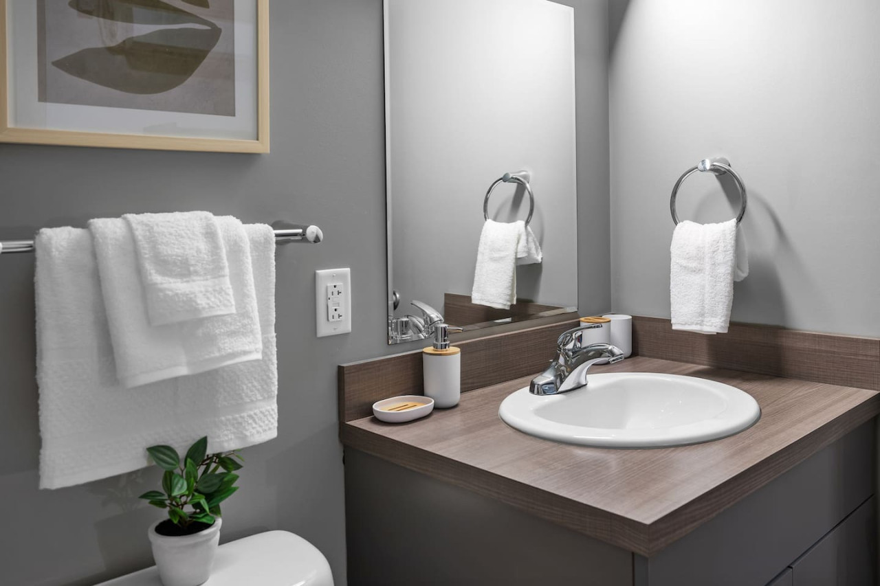 Immaculate bathroom featuring a spacious shower, fresh towels, and complimentary toiletries for a spa-like experience.