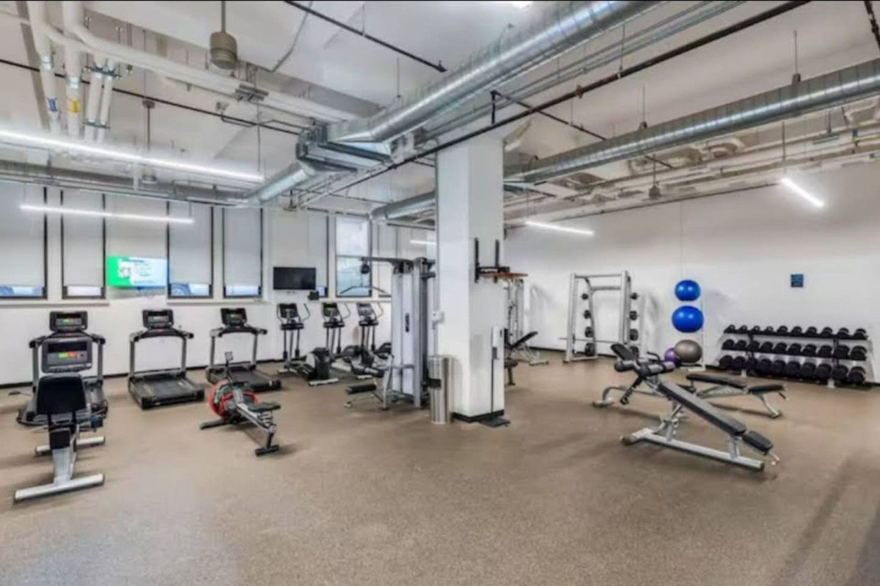 Open floor area with exercise mats, yoga balls, and foam rollers for warm-ups, stretching, or core exercises.