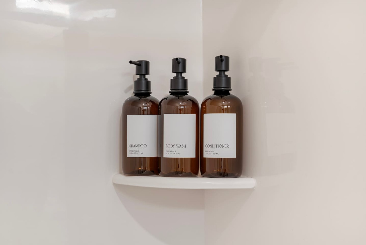 Immaculate bathroom featuring a spacious shower, fresh towels, and complimentary toiletries for a spa-like experience.