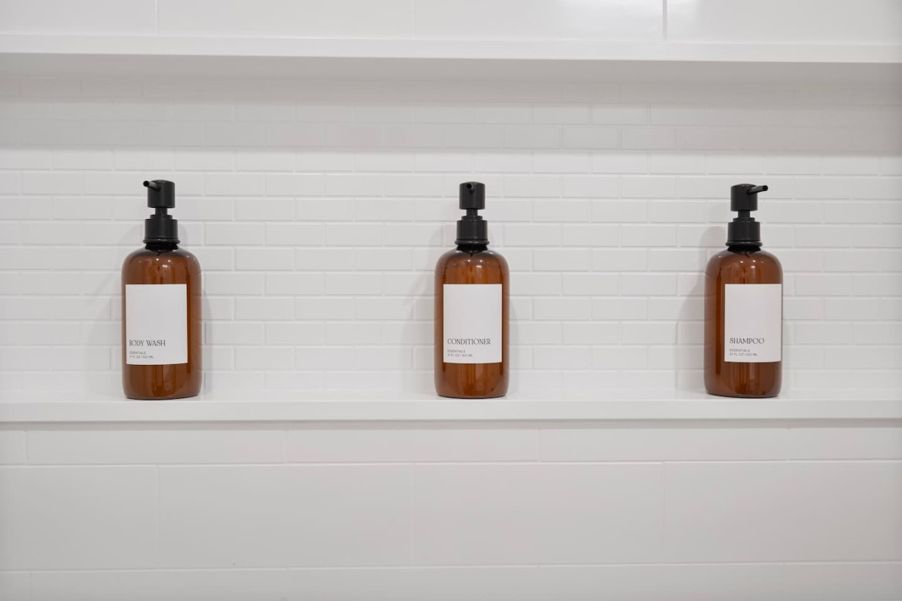 Immaculate bathroom featuring a spacious shower, fresh towels, and complimentary toiletries for a spa-like experience.