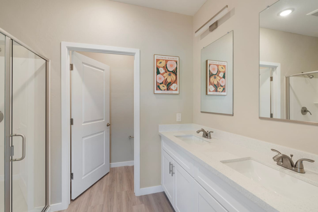 This bright and welcoming bathroom invites you to freshen up in comfort. Enjoy the forest-inspired shower curtain that adds a calming touch to your routine, complemented by the cozy rug underfoot and sparkling clean fixtures.