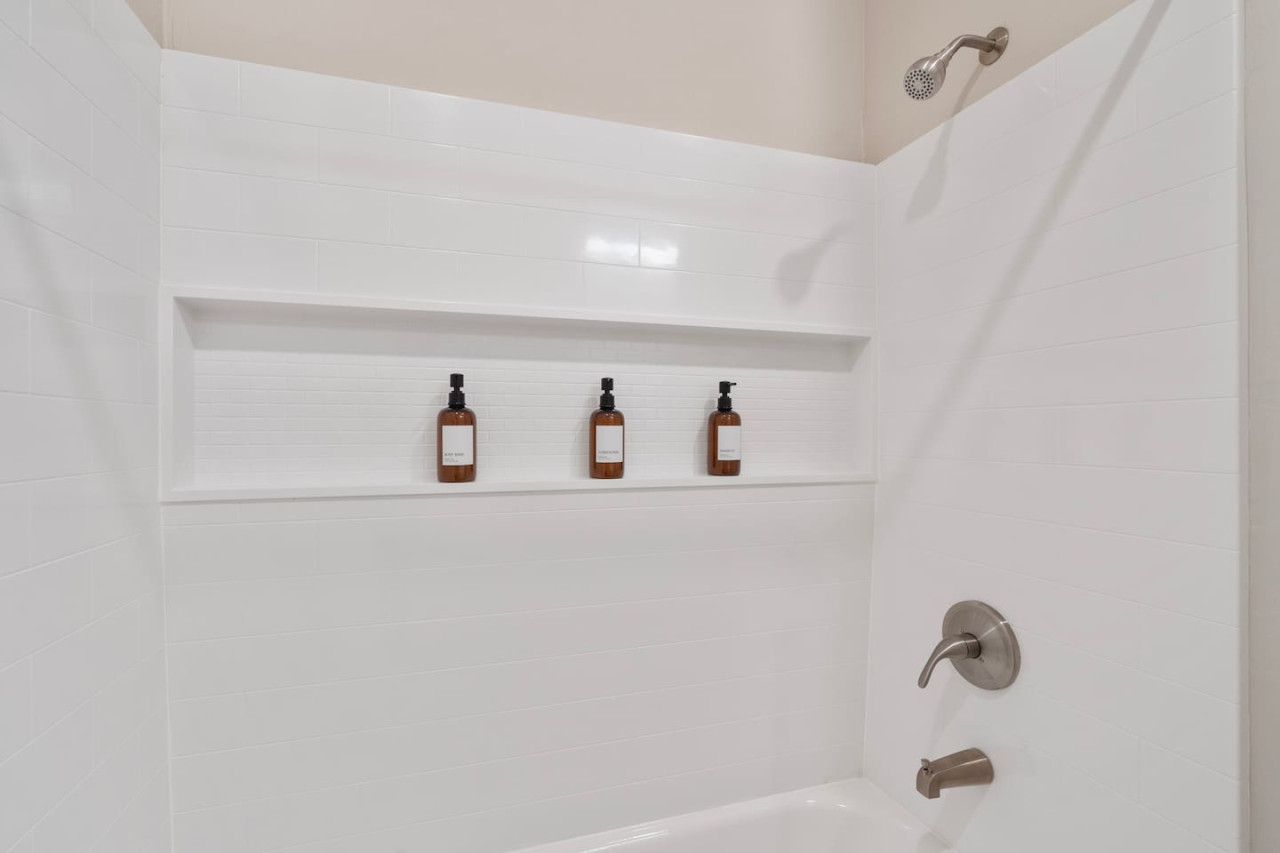 Immaculate bathroom featuring a spacious shower, fresh towels, and complimentary toiletries for a spa-like experience.