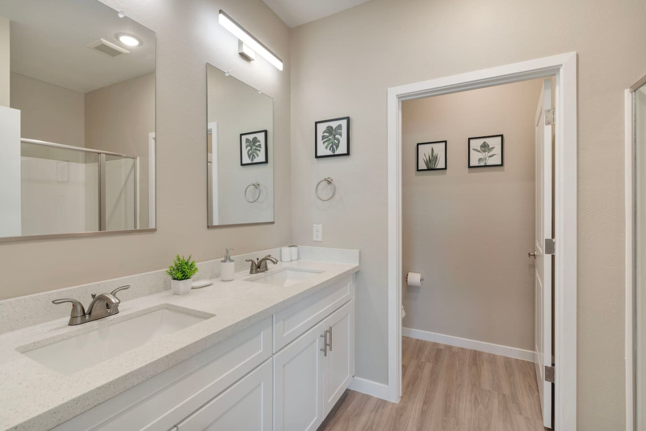 This bright and welcoming bathroom invites you to freshen up in comfort. Enjoy the forest-inspired shower curtain that adds a calming touch to your routine, complemented by the cozy rug underfoot and sparkling clean fixtures.