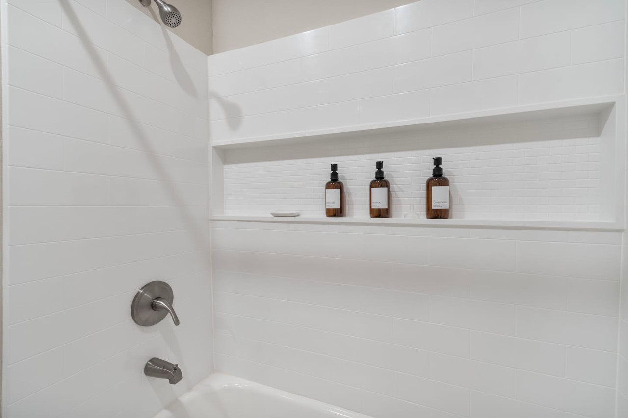 Immaculate bathroom featuring a spacious shower, fresh towels, and complimentary toiletries for a spa-like experience.