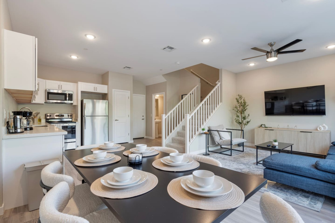 Spacious open-concept living and dining area featuring a vibrant sofa, modern furnishings, and a stylish entertainment setup—ideal for gatherings and relaxation.