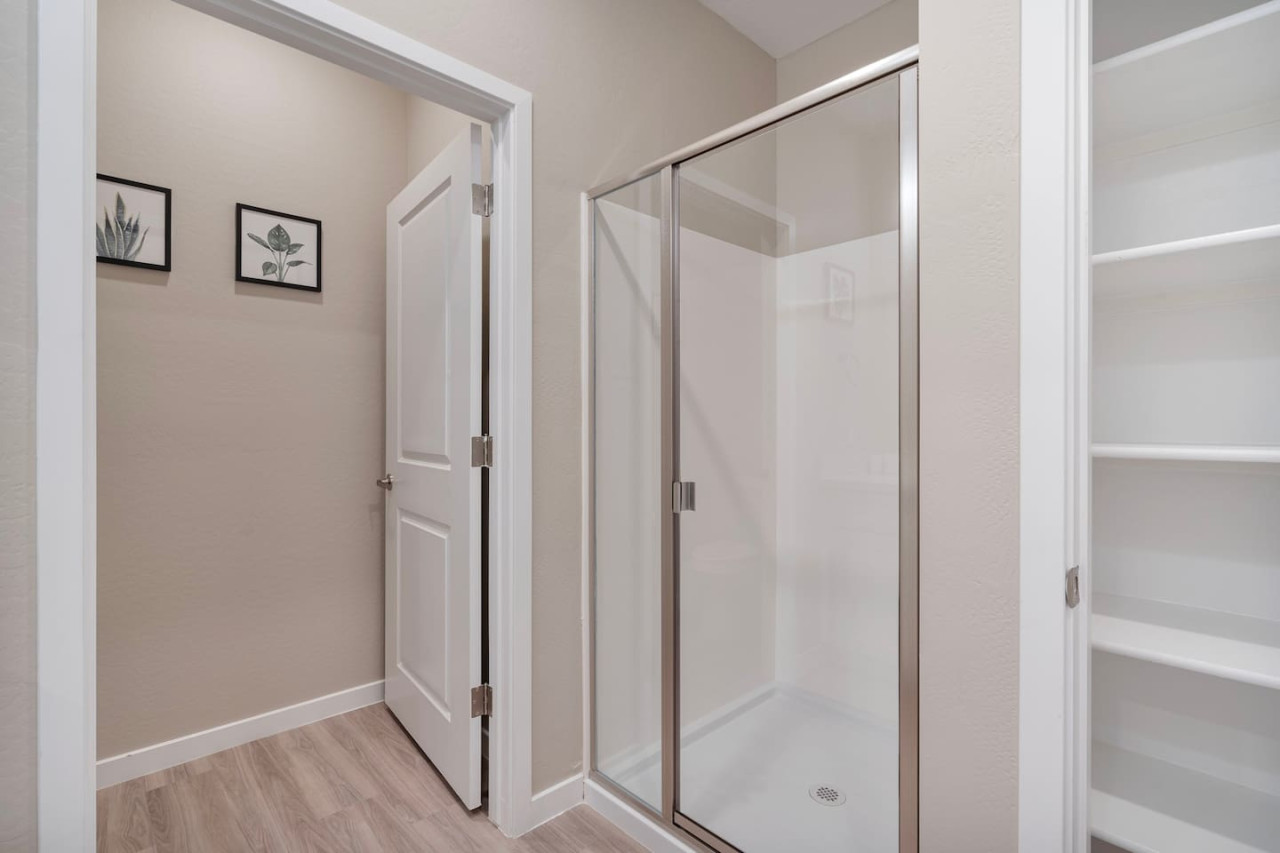 This bright and welcoming bathroom invites you to freshen up in comfort. Enjoy the forest-inspired shower curtain that adds a calming touch to your routine, complemented by the cozy rug underfoot and sparkling clean fixtures.