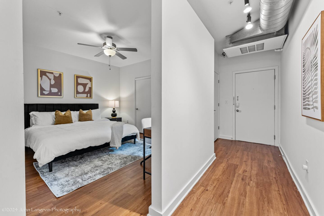 Retreat to the cozy master bedroom featuring a luxurious king-size bed with plush pillows, modern decor, blackout curtains, and a convenient workspace for all your needs.