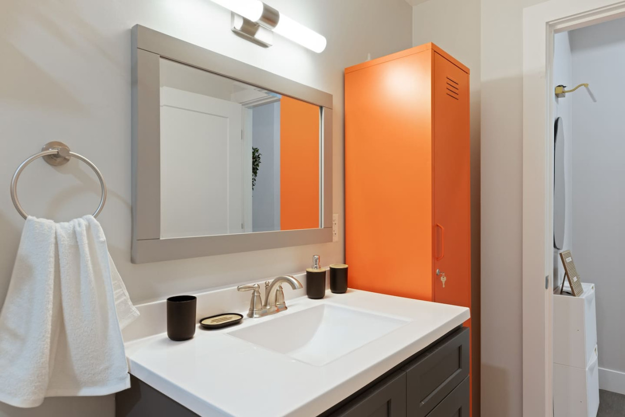 This bright and welcoming bathroom invites you to freshen up in comfort. Enjoy the forest-inspired shower curtain that adds a calming touch to your routine, complemented by the cozy rug underfoot and sparkling clean fixtures.