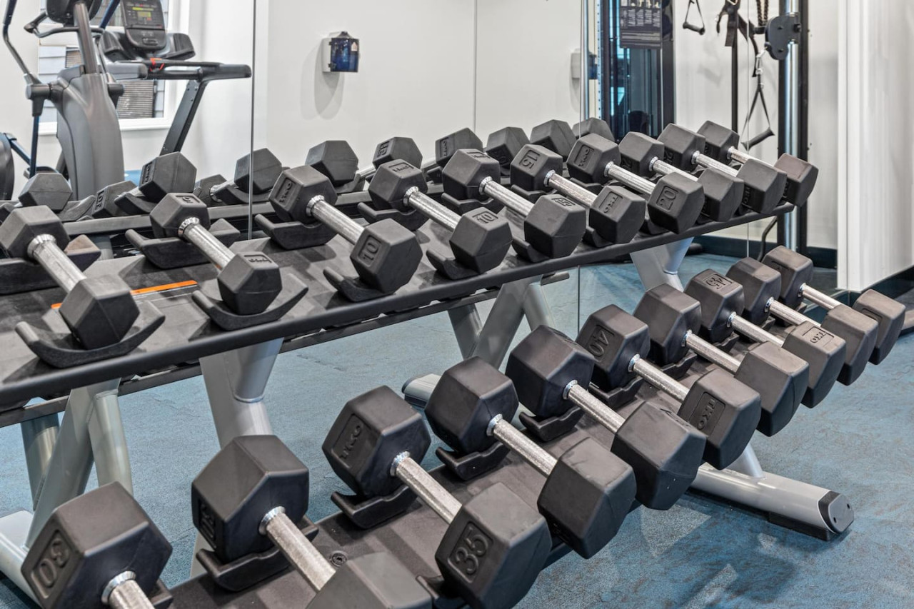 Dedicated space featuring a wide range of dumbbells, benches, and mirrors for strength and resistance training