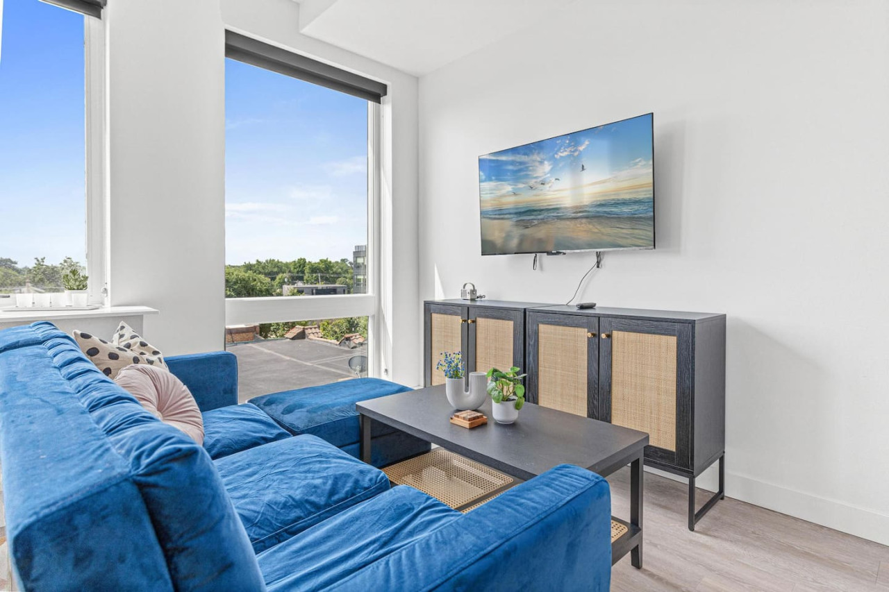Bright and airy living room with plush seating, a large TV, and tasteful decor, creating the perfect space for relaxation and entertainment.