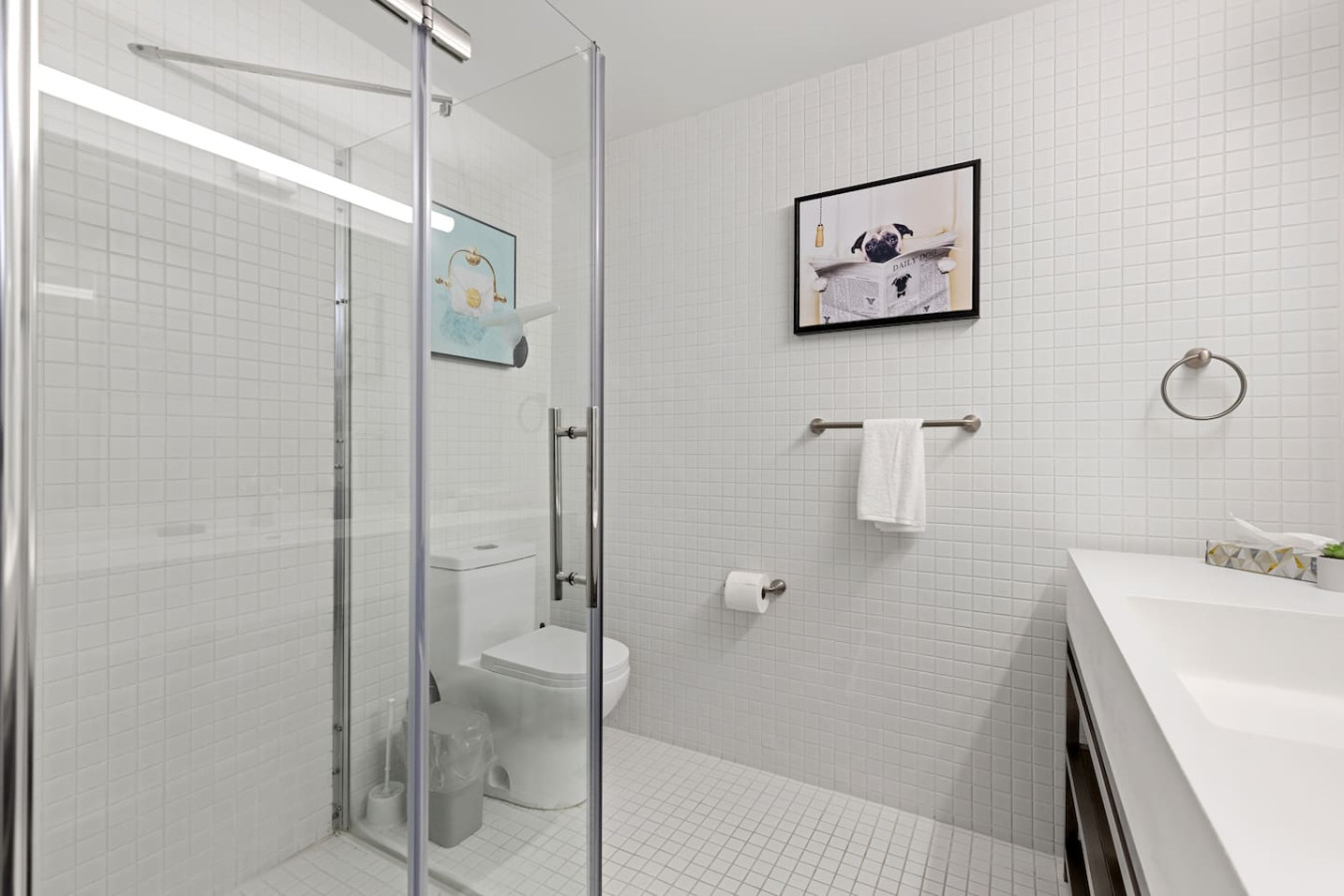 This bright and welcoming bathroom invites you to freshen up in comfort. Enjoy the forest-inspired shower curtain that adds a calming touch to your routine, complemented by the cozy rug underfoot and sparkling clean fixtures.