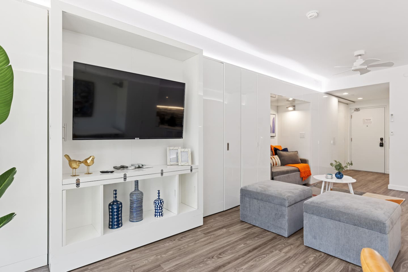 Enjoy a blend of modern comfort and style in this spacious living area. Featuring a plush sofa, chic decor, and a vibrant neon sign, it's perfect for relaxation and socializing. The open layout seamlessly connects to the kitchen and dining area.