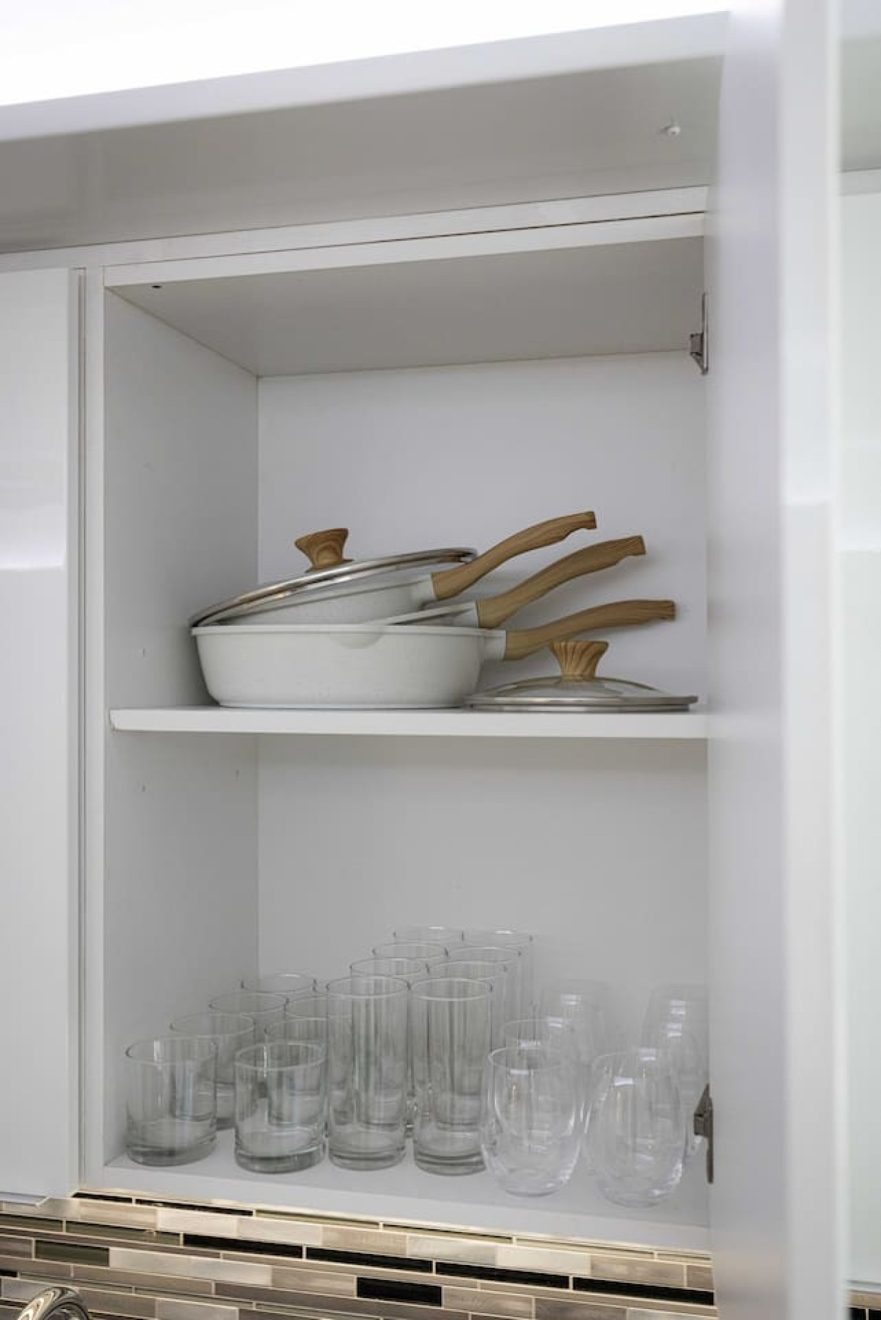Kitchen cabinets stocked with cooking wares, glassware and silverwares, ideal for mixing up your favorite meals and drinks during your stay.