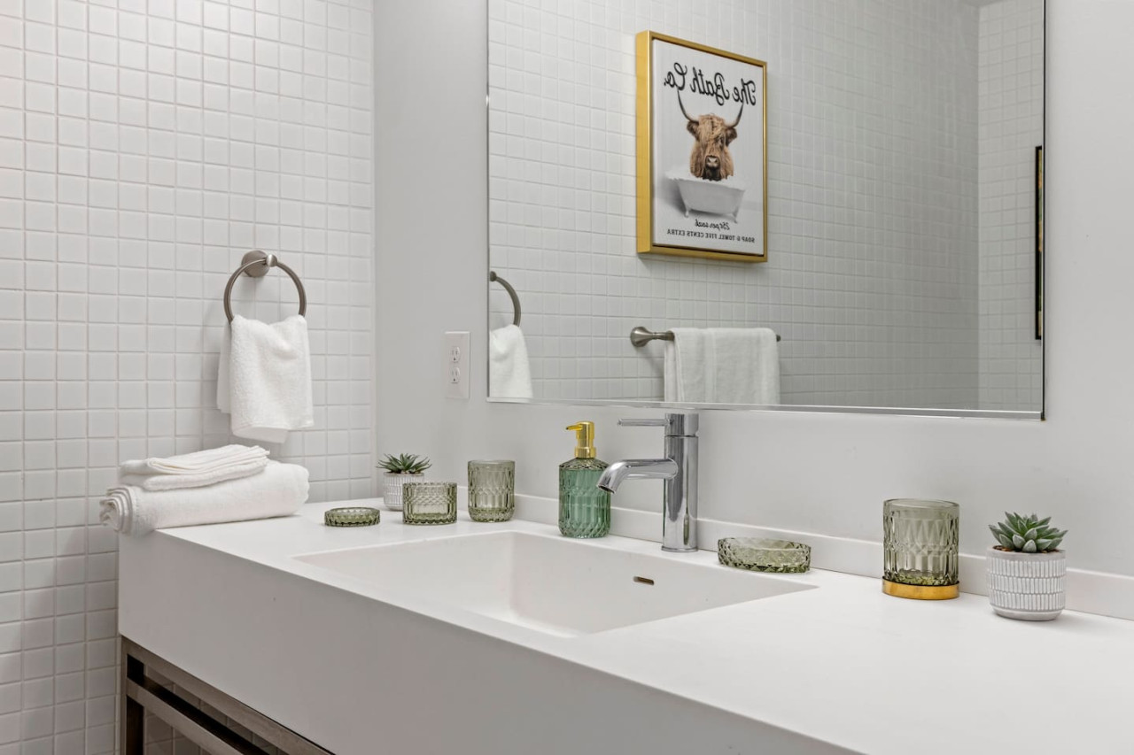 Immaculate bathroom featuring a spacious shower, fresh towels, and complimentary toiletries for a spa-like experience.