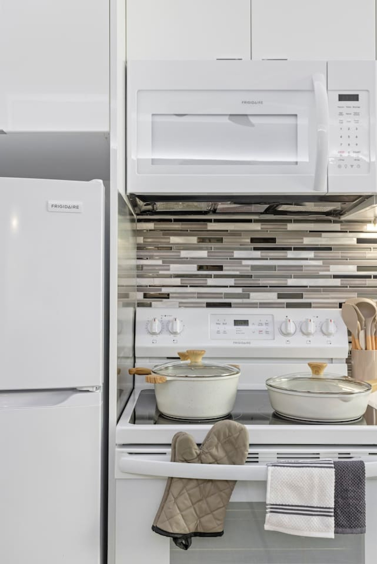Kitchen cabinets stocked with cooking wares, glassware and silverwares, ideal for mixing up your favorite meals and drinks during your stay.
