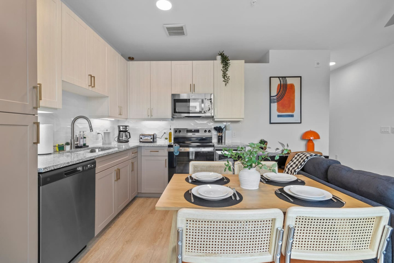 Spacious open-concept living and dining area featuring a vibrant sofa, modern furnishings, and a stylish entertainment setup—ideal for gatherings and relaxation.