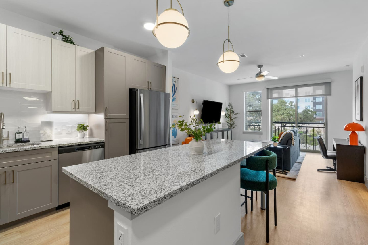 Spacious open-concept living and dining area featuring a vibrant sofa, modern furnishings, and a stylish entertainment setup—ideal for gatherings and relaxation.