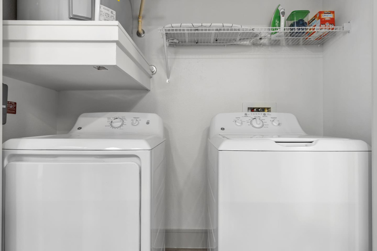 As you step into the laundry room, the modern appliances and ample storage space make it easy to keep things tidy.