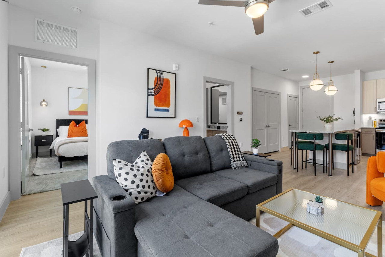 Bright and airy living room with plush seating, a large TV, and tasteful decor, creating the perfect space for relaxation and entertainment.