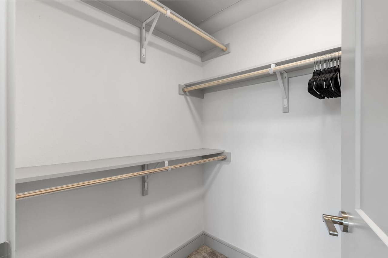 Sleek closet doors hide plenty of storage space, ensuring your room remains open and tidy during your stay.
