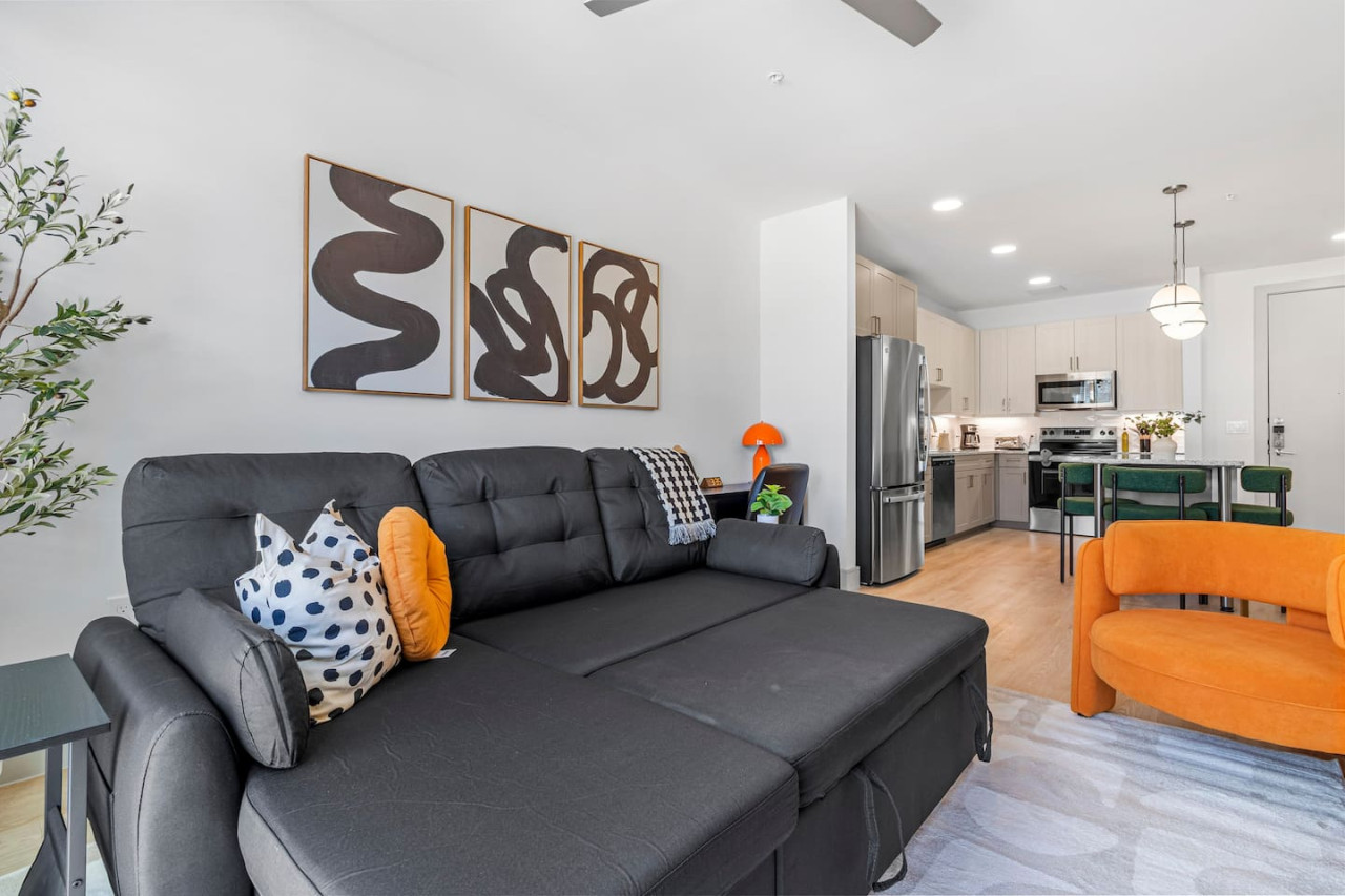 The living room’s plush seating beckons you to sink in and relax, surrounded by light and airy decor.
