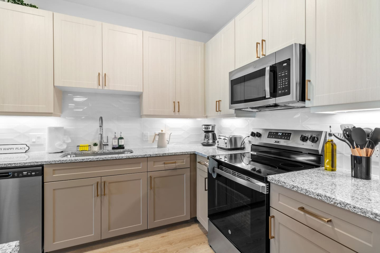 Cook with ease in this well-equipped kitchen featuring stainless steel appliances, ample cabinetry, and a stylish backsplash. Whether you're brewing coffee or preparing a gourmet meal, this space is designed for functionality and style, making every meal