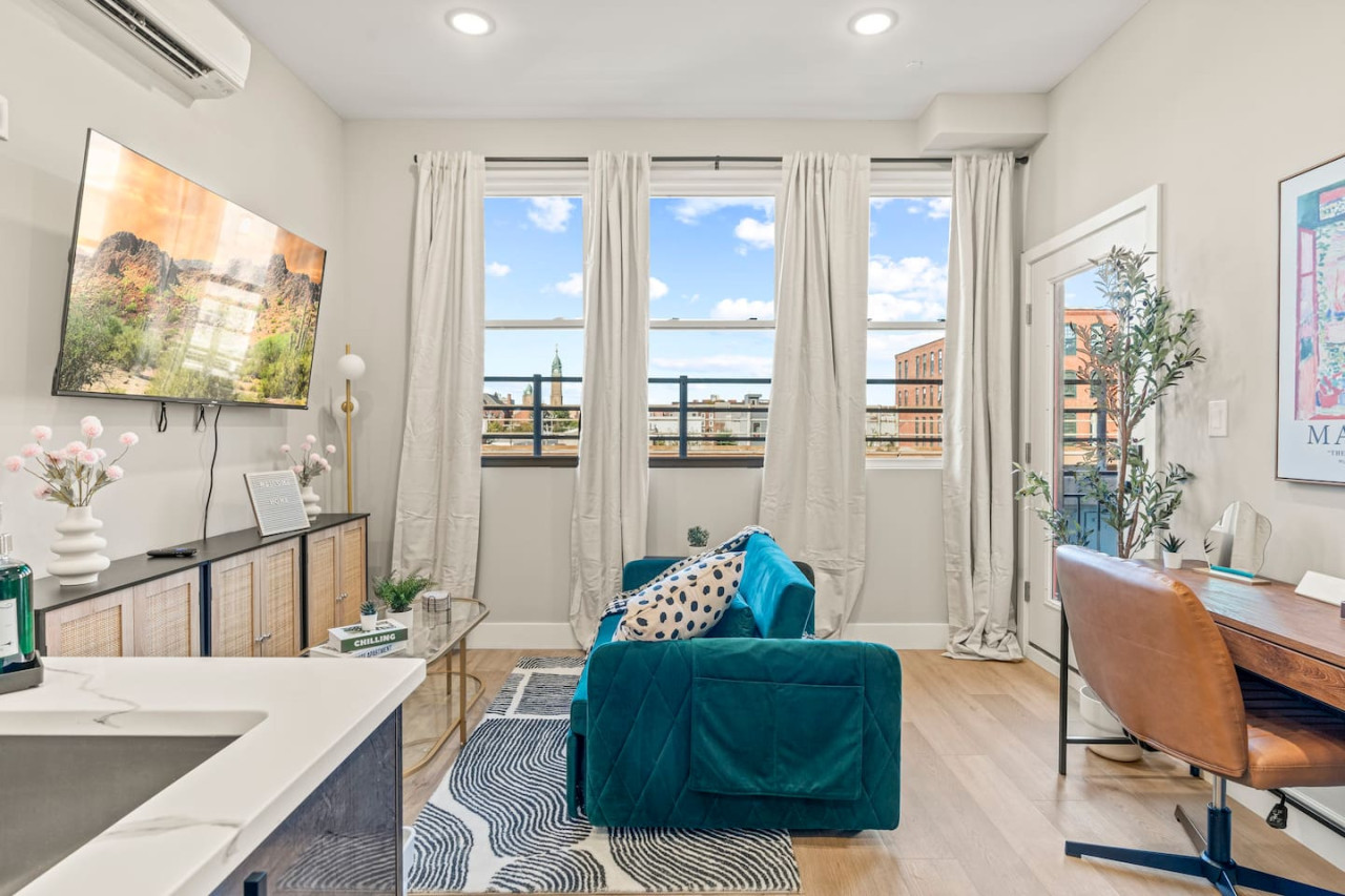 The living room’s plush seating beckons you to sink in and relax, surrounded by light and airy decor.