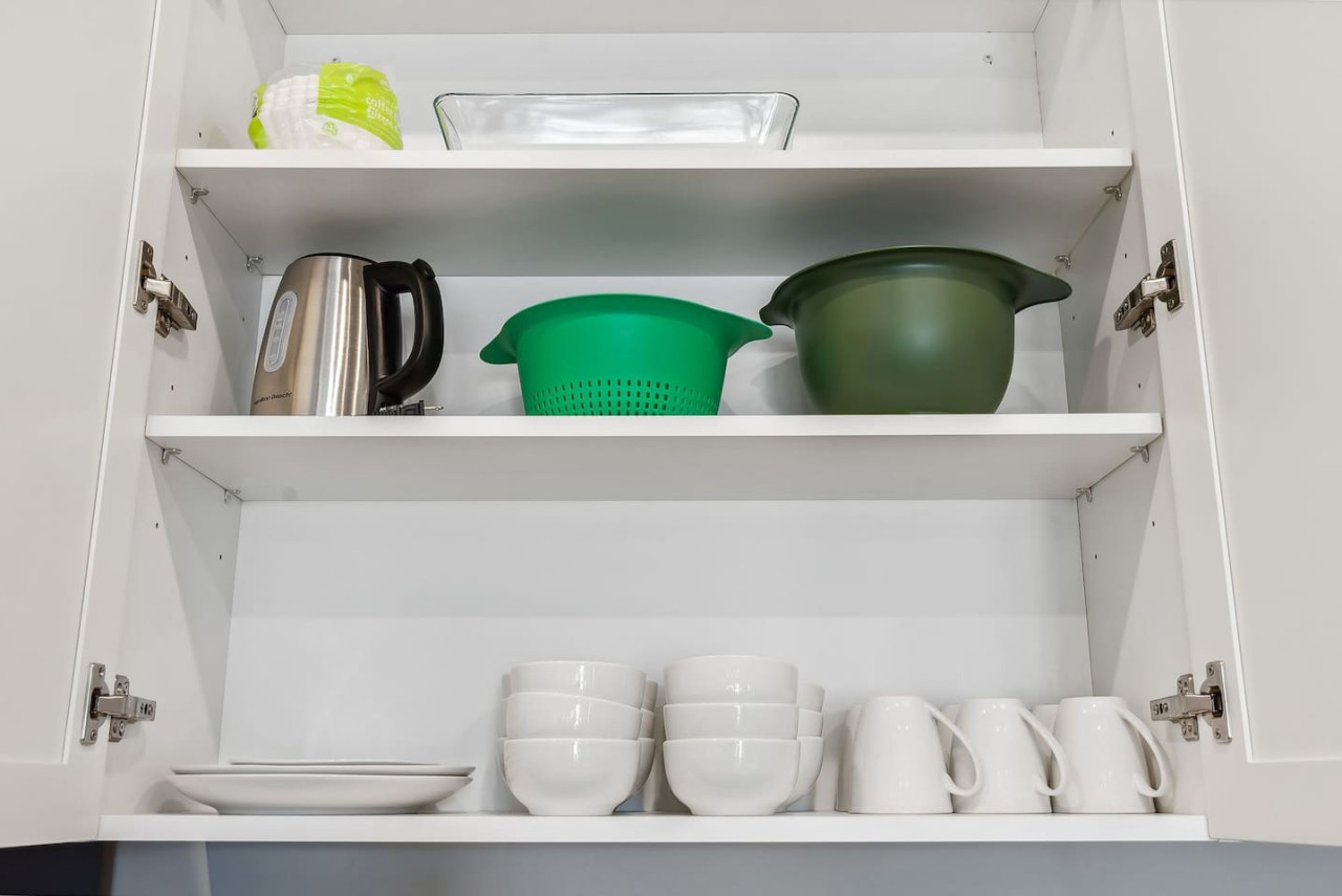 Kitchen cabinets stocked with cooking wares, glassware and silverwares, ideal for mixing up your favorite meals and drinks during your stay.