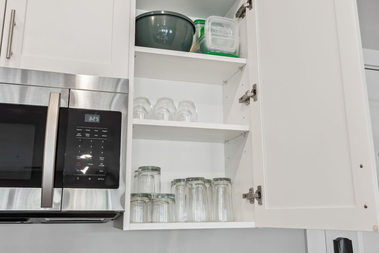 Kitchen cabinets stocked with cooking wares, glassware and silverwares, ideal for mixing up your favorite meals and drinks during your stay.