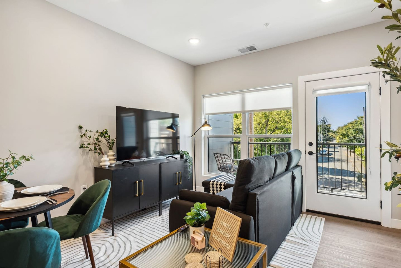 Bright and airy living room with plush seating, a large TV, and tasteful decor, creating the perfect space for relaxation and entertainment.