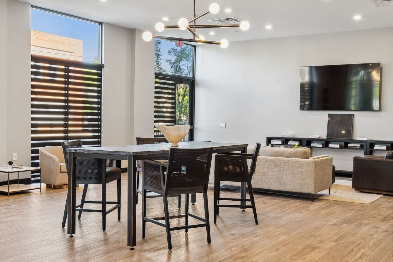 Spacious open-concept living and dining area featuring a vibrant sofa, modern furnishings, and a stylish entertainment setup—ideal for gatherings and relaxation.