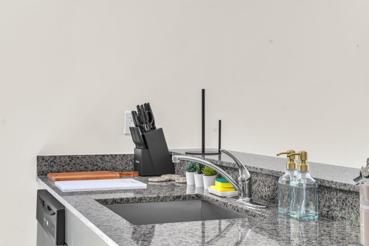 Granite countertop with a modern sink and knife set.