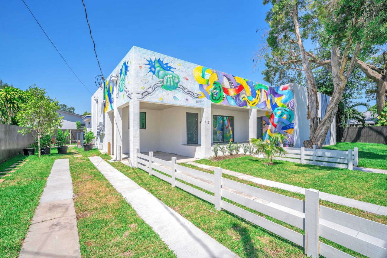 Vibrant exterior with artistic murals and lush greenery, creating a unique and welcoming curb appeal.