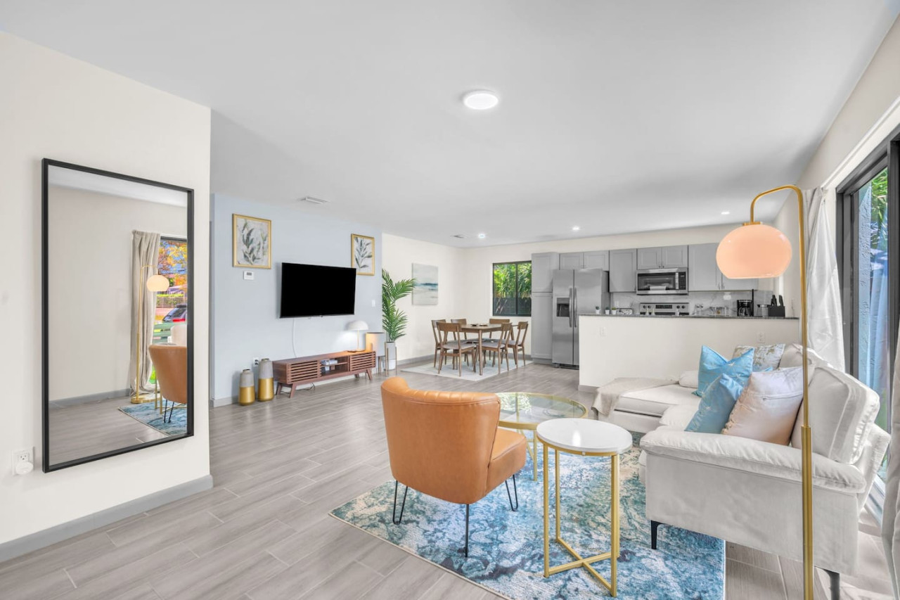 Stylish seating arrangement with a caramel accent chair, cozy throws, and a colorful area rug for a welcoming feel.