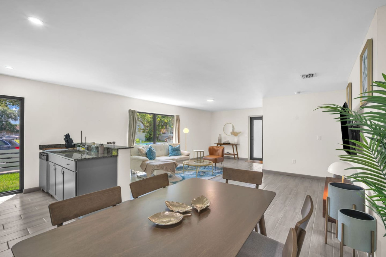 Spacious dining area with a mid-century modern table and chairs, seamlessly connected to the kitchen.