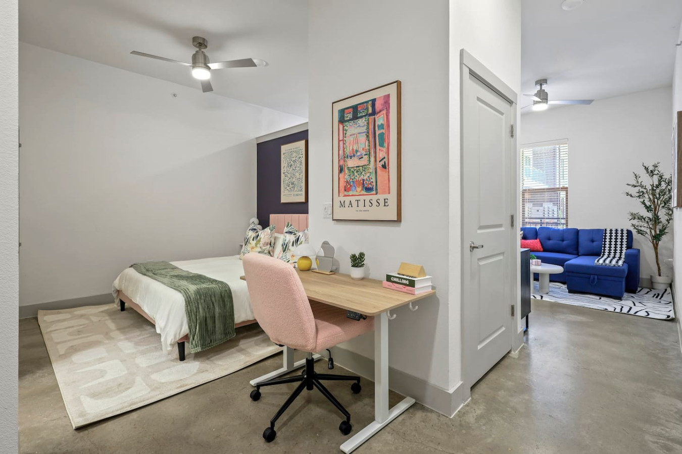 Spacious open-concept area featuring a vibrant blue sofa, modern furnishings, and a stylish entertainment setup—ideal for gatherings and relaxation.