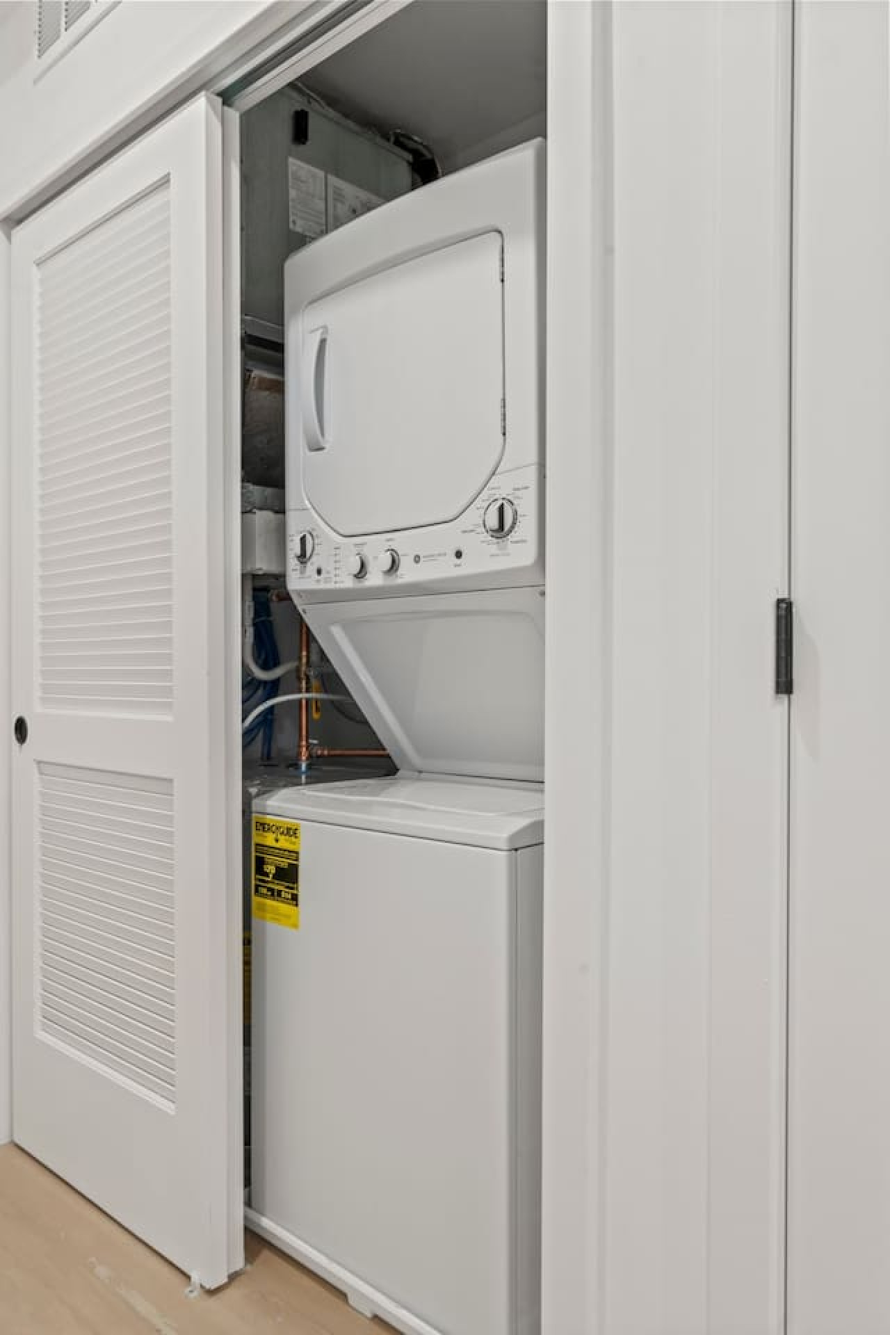 As you step into the laundry room, the modern appliances and ample storage space make it easy to keep things tidy.