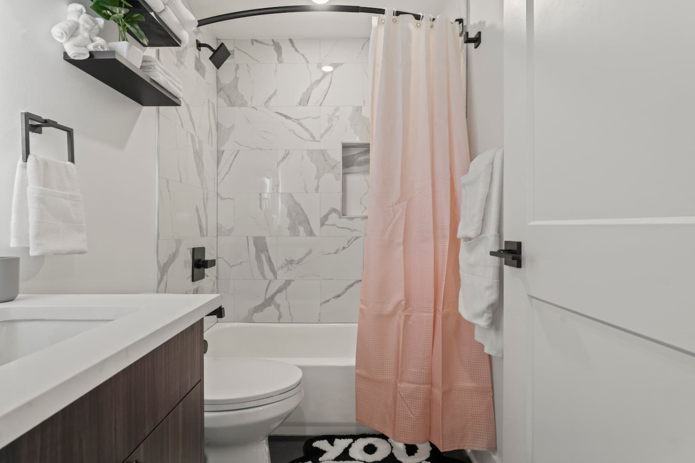 Modern bathroom with shower curtains and essentials provided (high quality linens, hairdryer, toilet paper)