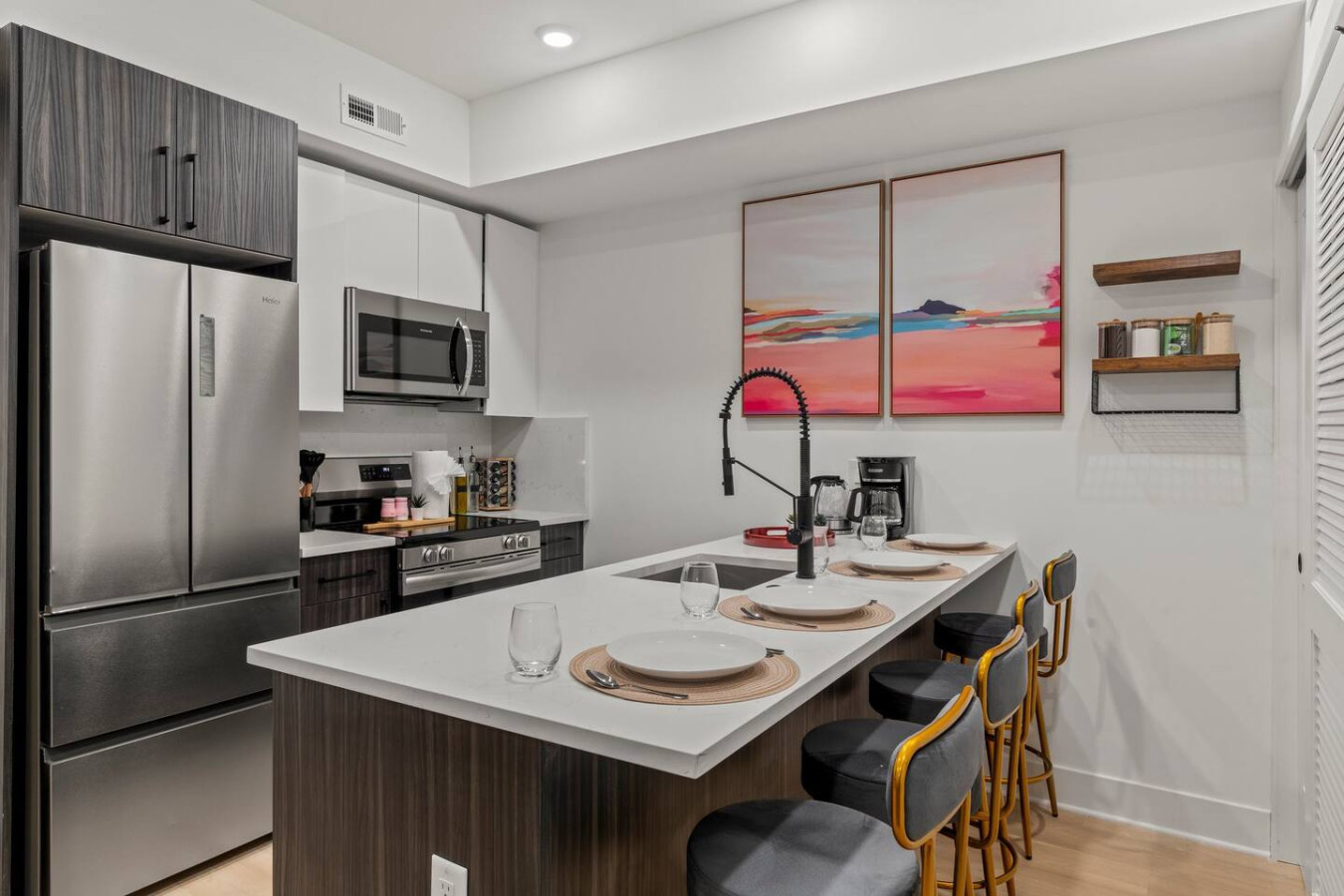 Dining area that seats 4 people with plates, mugs, and stainless steel flatware.
