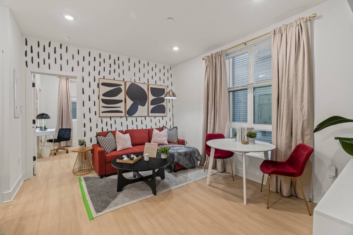 Spacious living room with accent sofa bed, coffee table, compact dining table and accent chairs