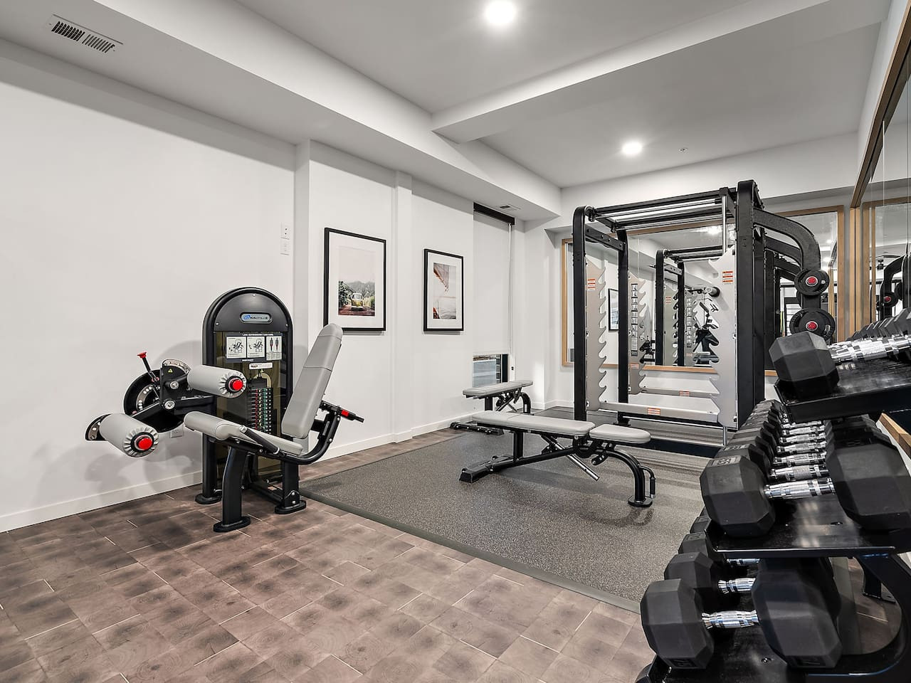 Spacious, well-lit gym equipped with a variety of cardio machines, free weights, and strength-training equipment.
