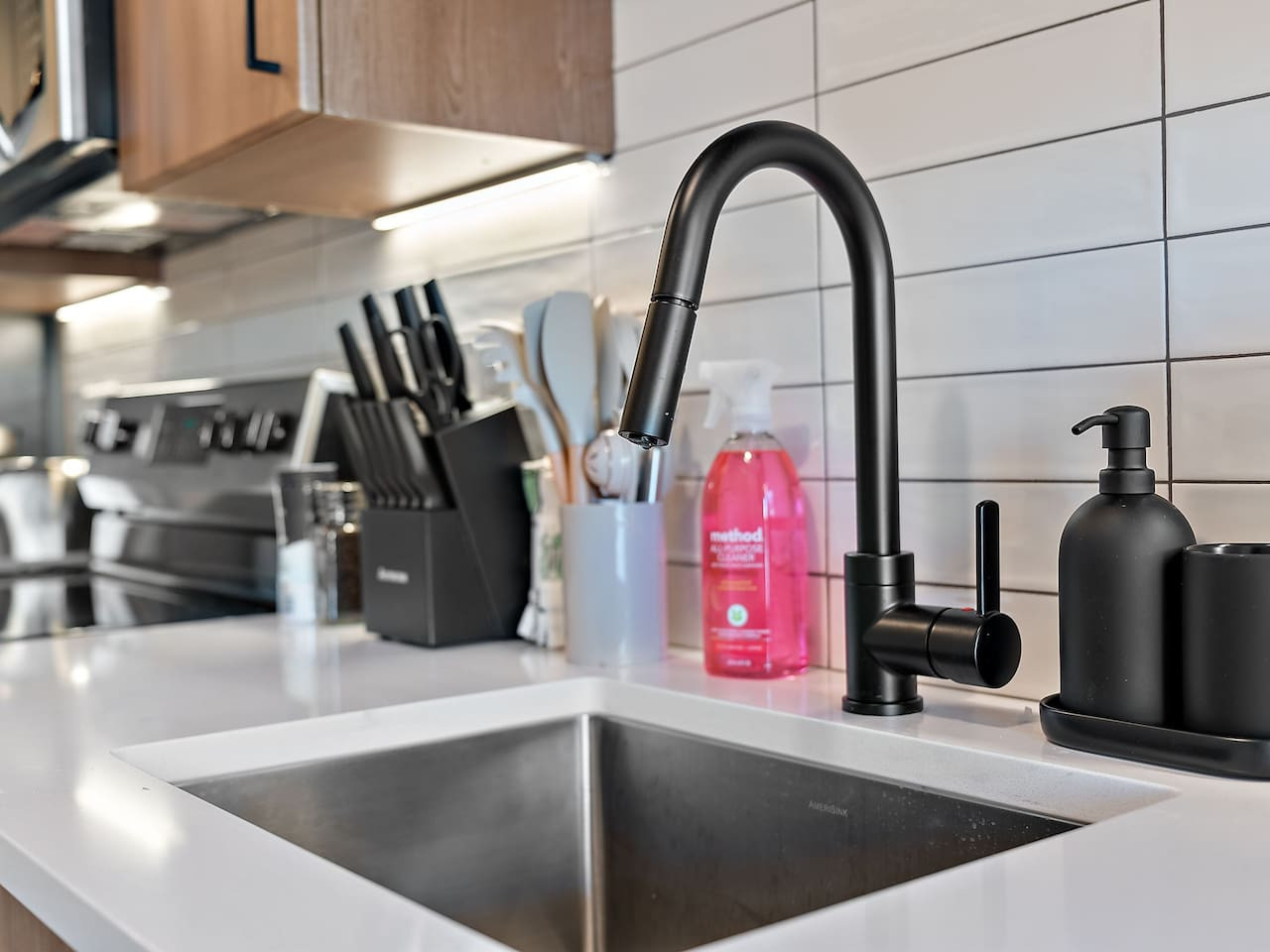 Prepare meals in this modern, fully-equipped kitchen featuring stainless steel appliances and a spacious island with bar seating. The open layout makes it easy to cook and entertain, ensuring a delightful culinary experience during your stay.