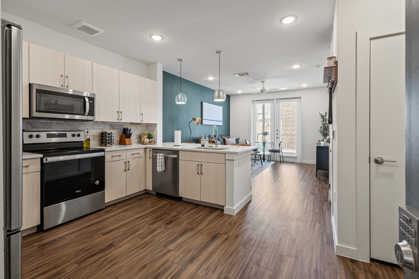 Bright, modern kitchen flows into spacious dining and living area with stylish finishes and plenty of natural light.